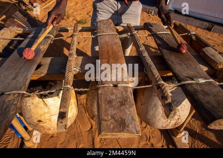 Trommler, die traditionelle afrikanische Kultur spielen, vergräbt Bassmbila (traditionelles Bassxylophon) mit Holzgummihämmern Stockfoto