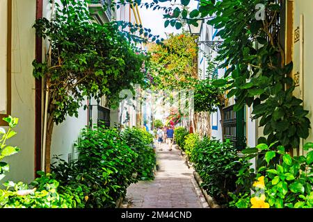 Eine farbenfrohe Gasse in Mogan Gran Canaria, mit farbenfrohen Pflanzen von Hibiskus und verschiedenen Arten und Schattierungen von Bougainvillea Stockfoto