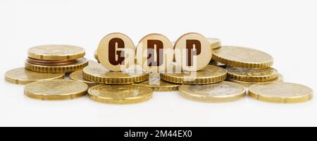 Geschäfts- und Finanzkonzept. Auf einer weißen Oberfläche liegen Münzen und Holzkreise mit der Inschrift -GDP Stockfoto