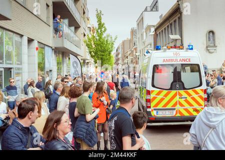 Genk. Limburg-Belgien 01-05-2022. Ein Krankenwagen kommt an einer Menschenmenge vorbei. Während der O-PARADE in Genk, Belgien. Jemand braucht dringend einen Arzt Stockfoto