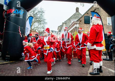 Breda, Niederlande. 18.. Dezember 2022. Die erste Gruppe von Kindern wird ausgeführt. Heute finden in vielen Städten in Ländern der ganzen Welt Santa Run-Veranstaltungen statt. In der niederländischen Stadt Breda liefen zweihundert Menschen, einschließlich Eltern mit ihren Kindern, während der Rotary Santa Run rund 3 km in Weihnachtskostümen. Die einmal jährlich stattfindende Veranstaltung wurde von der Stiftung „Rotary Santa Run“ organisiert. Die Veranstaltung brachte mindestens 8.000â‚¬ für zwei lokale Wohltätigkeitsorganisationen, die Stiftung "Youth Breakfast Breda Foundation" und die Stiftung "Het Bonte Perdje", ein, die jungen Menschen mit Behinderungen die Möglichkeit zum Praktizieren bieten soll Stockfoto