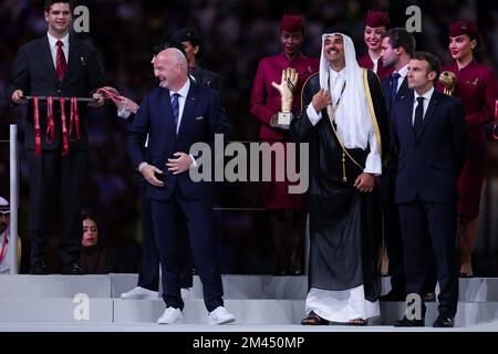 Doha, Katar. 18.. Dezember 2022. Katars Emir Sheikh Tamim bin Hamad al-Thani (C) steht nach dem letzten Fußballspiel der Katar-Weltmeisterschaft 2022 zwischen Argentinien und Frankreich im Lusail Stadium in Lusail, nördlich von Doha, am 18. Dezember 2022 zusammen mit dem FIFA-Präsidenten Gianni Infantino (L) und dem französischen Präsidenten Emmanuel Macron (R). (Foto: William Volcov) Kredit: Brazil Photo Press/Alamy Live News Stockfoto