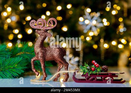 Glitzernder Rainder mit Schlitten im Weihnachtshintergrund. Stockfoto