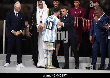 Lusail, Katar, 18. Dezember 2022. Argentiniens Stürmer Lionel Messi schüttelt sich mit dem französischen Präsidenten Emmanuel Macron die Hand, nachdem er den Golden Ball Award für den besten Spieler von Katars Emir Sheikh Tamim bin Hamad al-Thani während der Trophäenzeremonie am Ende des Katar-Weltmeisterschaftsfinals 2022 zwischen Argentinien und Frankreich erhalten hatte Lusail Stadium in Lusail, nördlich von Doha, Katar am 18. Dezember 2022. Foto: David Niviere/ABACAPRESS.COM Stockfoto