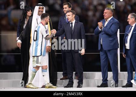 Lusail, Katar, 18. Dezember 2022. Argentiniens Stürmer Lionel Messi schüttelt sich mit dem französischen Präsidenten Emmanuel Macron die Hand, nachdem er den Golden Ball Award für den besten Spieler von Katars Emir Sheikh Tamim bin Hamad al-Thani während der Trophäenzeremonie am Ende des Katar-Weltmeisterschaftsfinals 2022 zwischen Argentinien und Frankreich erhalten hatte Lusail Stadium in Lusail, nördlich von Doha, Katar am 18. Dezember 2022. Foto: David Niviere/ABACAPRESS.COM Stockfoto