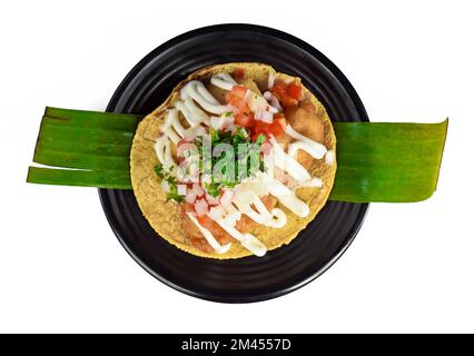 Taco condesa mit gebratenem Fisch auf schwarzem Teller isoliert auf weißem Hintergrund Stockfoto