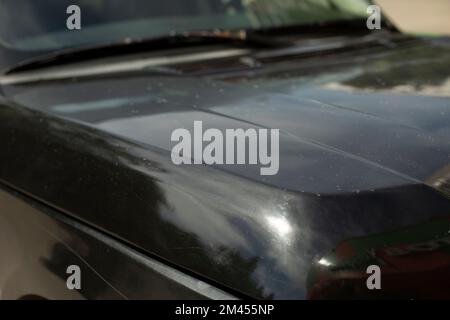 Transport im Detail. Fahrzeugkarosserie. Das Auto steht auf dem Parkplatz. Schwarze Farbe an der Maschine. Stockfoto