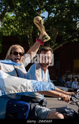 La Plata, Buenos Aires, Argentinien - 18. Dezember 2022: Fans auf einem Motorrad mit argentinischer Flagge und einem Pokal feiern Argentinien mit dem Sieg der FIF 2022 Stockfoto