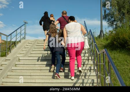 Die Leute gehen im Park die Treppe hoch. Menschen steigen in der Stadt Treppen. Die Treppe nach draußen. Leute von hinten. Stockfoto