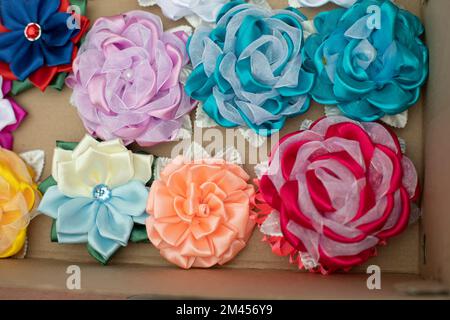 Schleifen aus Stoff. Handgefertigte Haarspangen. Blumen aus Stoffklappen. Haarschmuck. Details von FAIR. Stockfoto