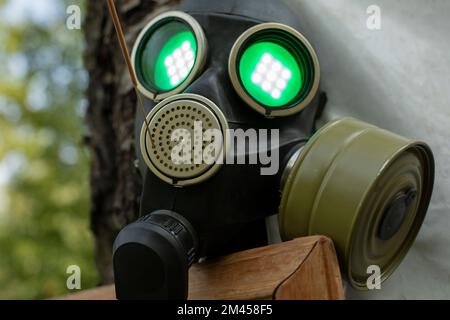 Dampf Punk Gasmaske. Leuchtende Augen bei der Maske. Maske auf Gesicht von Gas. Details Zur Festspieldekoration. Licht in runden Gläsern. Stockfoto