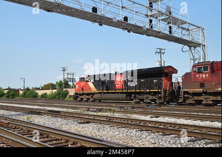 Franklin Park, Illinois, USA. Lokomotiven, angeführt von einer kanadischen Eisenbahneinheit, treiben einen Güterzug in Richtung eines Bahnhofs an. Stockfoto