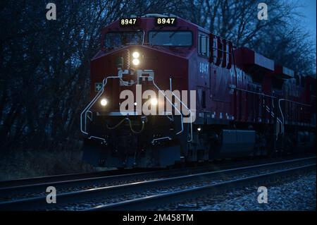 Bartlett, Illinois, USA. Die Lokomotiven der Canadian Pacific Railway treiben einen Güterzug durch den Nordosten von Illinois an, während die Nacht die Gegend überwindet. Stockfoto