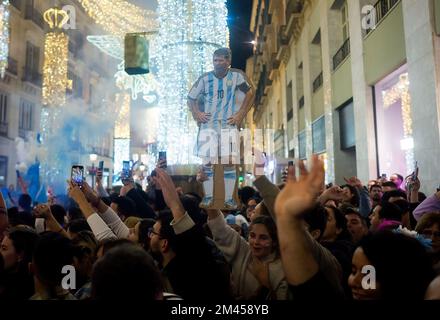 Malaga, Spanien. 18.. Dezember 2022. Ein Banner, das den argentinischen Fußballer Lionel Messi darstellt, wird während der Feier des argentinischen Sieges auf der Straße Marques de Larios gesehen. In festlicher Atmosphäre sind Tausende argentinischer Einwohner der Stadt Malaga auf die Straßen des Stadtzentrums gegangen, um den Sieg der argentinischen Nationalmannschaft zu feiern, nachdem sie während des Finales der FIFA-Weltmeisterschaft Katar 2022 gegen Frankreich siegten. Kredit: SOPA Images Limited/Alamy Live News Stockfoto