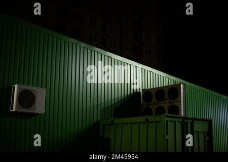 Das Lagergebäude ist dunkel. Grüne Mauer bei Nacht. Filialdetails. Technische Struktur. Stockfoto