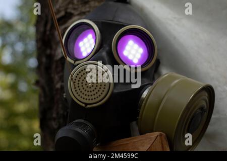 Gasmaske mit Flamme in den Augen. Violettes Licht aus Augenhöhlen. Rauchschutz Altes Ding im Steam-Punk-Stil. Stockfoto