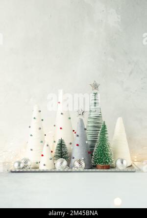 Handgefertigte Weihnachtsbäume. Garnumwickelte Kegelbäume. WEIHNACHTSGESCHENKE. DIY-Konzept Stockfoto