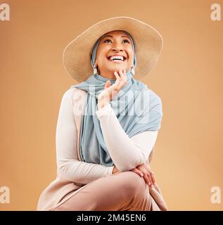 Hijab, Mode und fröhliche Frau denken im Studio-Hintergrund, trendige Mütze und Sommer-Style. Lachen, Glück und reifes muslimisches Modell, islamisch Stockfoto