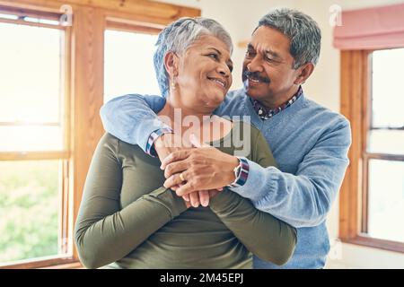 Unsere Liebe wird von Tag zu Tag stärker. Ein liebevolles Seniorenpaar, das in ihrem Haus posiert. Stockfoto