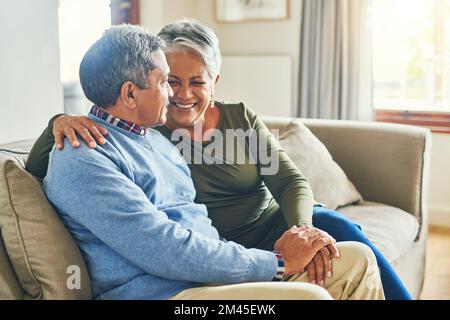 Dich zu lieben ist der beste Teil meines Lebens. Ein liebevolles Seniorenpaar, das sich zu Hause auf dem Sofa entspannt. Stockfoto