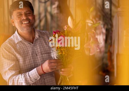Ein glücklicher Blumenhändler, der Blumenstrauß macht Stockfoto