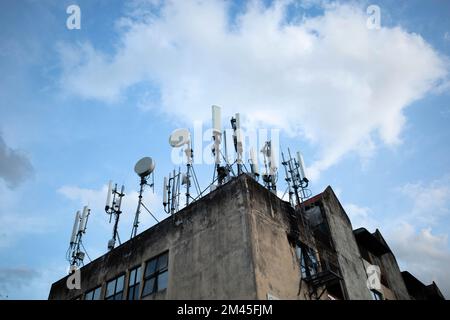 Mehrere mobile Übertragungstürme, die an einem stationären Gebäude befestigt sind Stockfoto