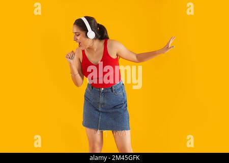 Teenager singen, während sie Musik über Kopfhörer hören Stockfoto