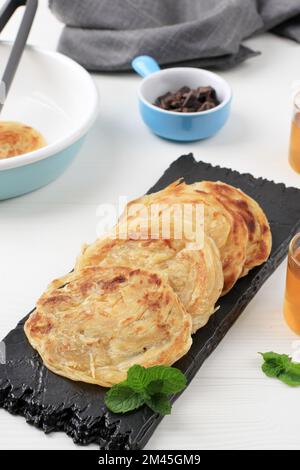 Roti Canai oder Paratha Parotta Flat Bread, auch bekannt als Roti Maryam in Indonesien. Kann mit Curry oder Sweet Topping serviert werden Stockfoto