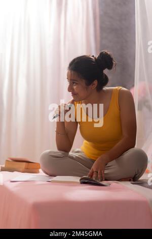 Porträt eines Teenagers, das im Schlafzimmer lernt Stockfoto