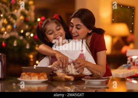 Mutter und Tochter machen zu Hause Weihnachtskuchen Stockfoto