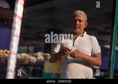 Männlicher Verkäufer macht Teig für litti an seinem Imbissstand am Straßenrand Stockfoto