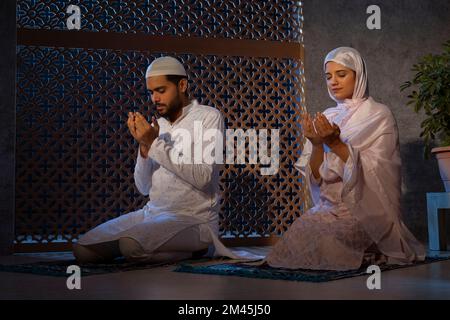 Porträt eines muslimischen Paares, das zu Hause zusammen betet Stockfoto