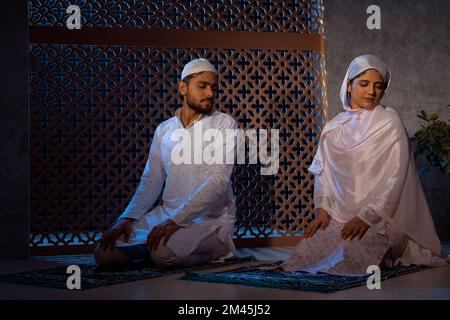 Porträt eines muslimischen Paares, das zu Hause zusammen betet Stockfoto