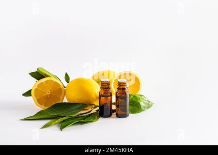 Zwei medizinische Flaschen braunes Glas mit einem Tropfer mit ätherischem Zitronenöl auf weißem Hintergrund mit einer Kopie des Raums. Aromatherapie, Entspannung Stockfoto