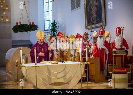 Altoetting, Deutschland-Dezember 17,2022 : Männer als St. verkleidet Nicholas hören während einer Messe auf der traditionellen jährlichen Pilgerfahrt zu. Stockfoto