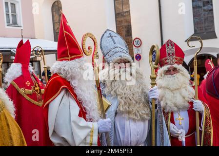 Altoetting, Deutschland-Dezember 17,2022 : Männer als St. verkleidet Nicholas verlassen die Kirche nach einer Messe während der traditionellen jährlichen Pilgerfahrt. Stockfoto