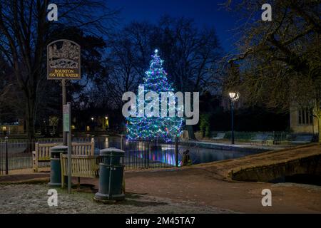 Weihnachtsbaum im Frost bei Sonnenaufgang. Bourton on the Water, Cotswolds, Gloucestershire, England Stockfoto