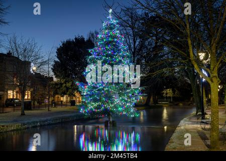 Weihnachtsbaum im Frost bei Sonnenaufgang. Bourton on the Water, Cotswolds, Gloucestershire, England Stockfoto