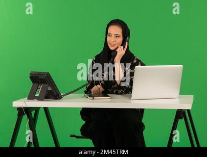 Eine Araberin, die im Büro telefoniert. Stockfoto