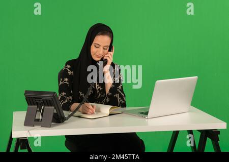 Eine Araberin, die im Büro telefoniert. Stockfoto