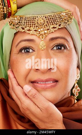 Gesicht, Schönheit und Schmuck auf einer ägyptischen Frau mit Händen auf Gesicht für arabische Kultur, mit Händen auf Gesicht für Mode und Hautpflege. Porträt eines reifen Menschen Stockfoto