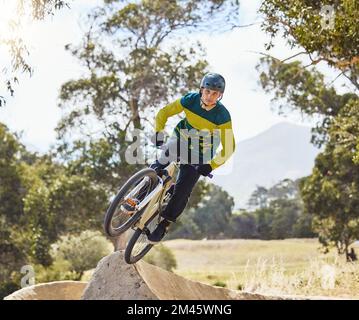 Mountainbike-Mann, Luftrampe und Outdoor mit Helm, Extremsport und Konzentration auf Fitness, Geschwindigkeit und Training. BMX-Fahrrad. Sportexperte und schneller Sprung Stockfoto