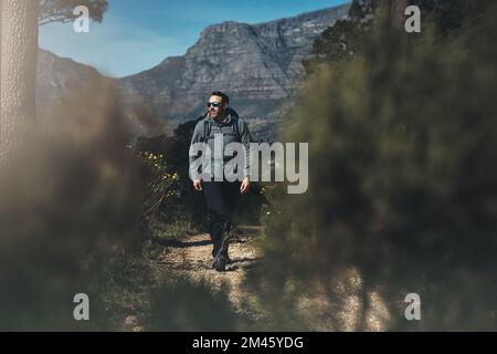 Geh raus und finde, wonach du dich sehnst. Aufnahme eines Mannes mittleren Alters, der in den Bergen wandert. Stockfoto