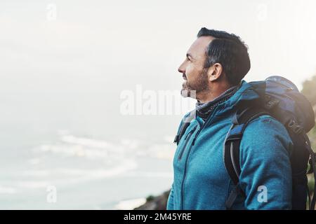 Sei immer dankbar, wenn du Höhen erreichst, die du dir nie vorgestellt hast. Ein Mann mittleren Alters, der die Aussicht auf einen Berg betrachtet. Stockfoto