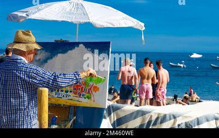 23. April 2022 - Positano Italien Ein Maler steht mit seiner Staffelei auf der Straße und malt die bunten Häuser an der Amalfiküste Stockfoto