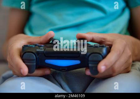 Junge, die zu Hause Videospiele spielen, Online-Unterhaltung und Freizeitaktivitäten Stockfoto