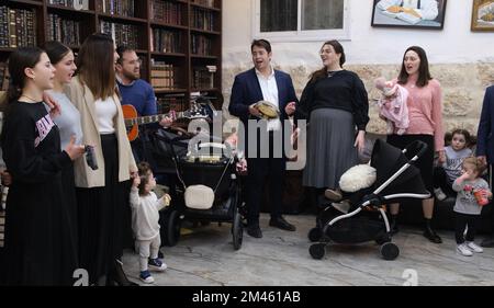 JERUSALEM, ISRAEL - DEZEMBER 18: Die Familie von Rabbi Yitzchak Goldstein, dem Leiter der Diaspora Jeshiva, singt ein traditionelles Chanukkka-Lied, nachdem sie am ersten Abend des jüdischen Feiertags von Chanukka, manchmal auch als Lichterfest bezeichnet, eine Kerze angezündet hat, am 18. Dezember 2022 in Jerusalem, Israel. Juden auf der ganzen Welt feiern heute den ersten Tag von Hanukkah, dem achttägigen jüdischen Festival. Hanukka oder Chanukah gedenkt dem jüdischen Sieg 165 v. Chr. über die syrisch-griechische Unterdrückung unter der Führung von König Antiochus IV Kredit: Eddie Gerald/Alamy Live News Stockfoto