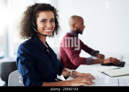 Waren immer hilfsbereit. Gekürztes Porträt einer attraktiven jungen Call-Center-Agentin, die in ihrem Büro arbeitet. Stockfoto