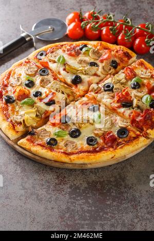 Capricciosa eine klassische Pizza mit Artischocken, Oliven, Schinken und Pilzen auf dem Holzbrett auf dem Tisch. Vertikal Stockfoto