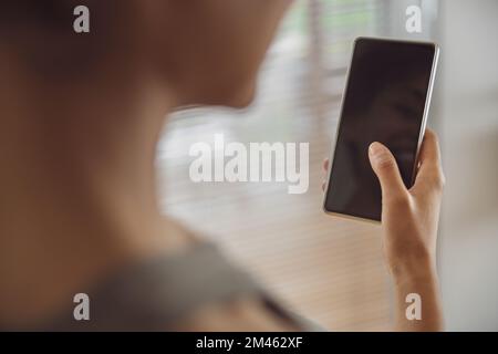 Nahaufnahme einer Frau, die ihr Smartphone in der Hand hält. Werbekonzept für mobile Apps Stockfoto